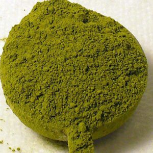 Compressed green powder on white background.